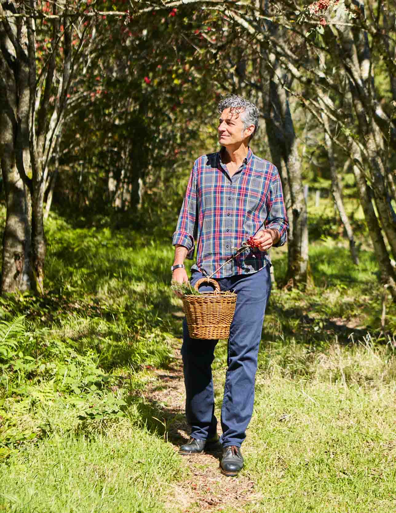 Dr. Markus Strauß mit Weidenkorb auf einem sonnigen Waldweg